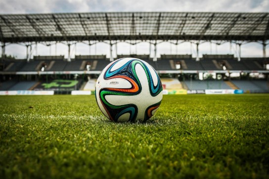veelkleurige voetbal op groen veld (vergroot foto)